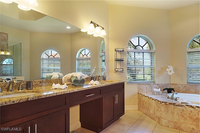bathroom with plenty of natural light, tile patterned flooring, a garden tub, and double vanity