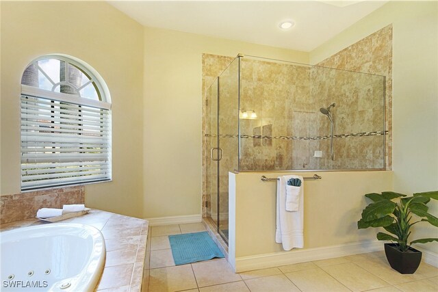 bathroom featuring a stall shower, a whirlpool tub, and tile patterned floors