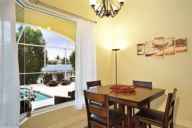 dining space with a chandelier, baseboards, and arched walkways