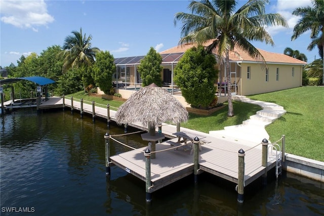 dock area with a water view, a yard, and a lanai