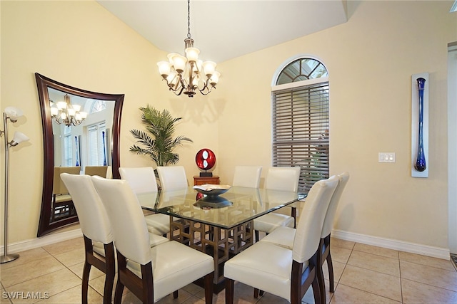dining room with a chandelier, baseboards, light tile patterned flooring, and lofted ceiling