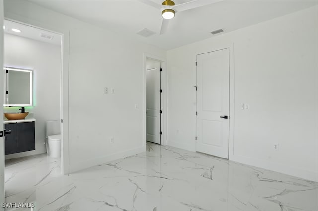 35 Chiquita Blvd N, Cape Coral, FL 33993 - unfurnished bedroom with baseboards, ensuite bathroom, light marble finish floors, and ceiling fan