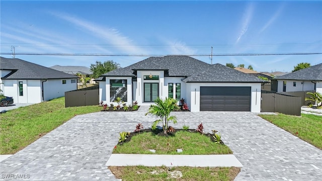 35 Chiquita Blvd N, Cape Coral, FL 33993 - view of front of home featuring an attached garage, stucco siding, decorative driveway, and a shingled roof