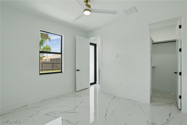 35 Chiquita Blvd N, Cape Coral, FL 33993 - unfurnished bedroom with baseboards, a walk in closet, ceiling fan, light marble finish flooring, and a closet