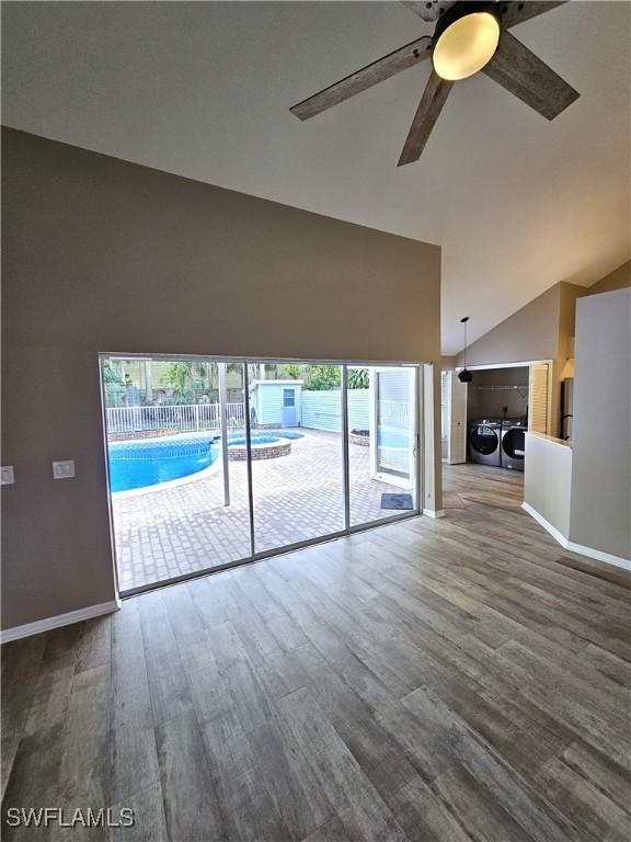 1431 Monarch Cir Unit B8, Naples, FL 34116 - unfurnished living room with independent washer and dryer, high vaulted ceiling, a ceiling fan, wood finished floors, and baseboards