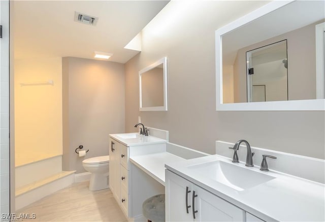 1431 Monarch Cir Unit B8, Naples, FL 34116 - bathroom with toilet, two vanities, wood finished floors, and baseboards