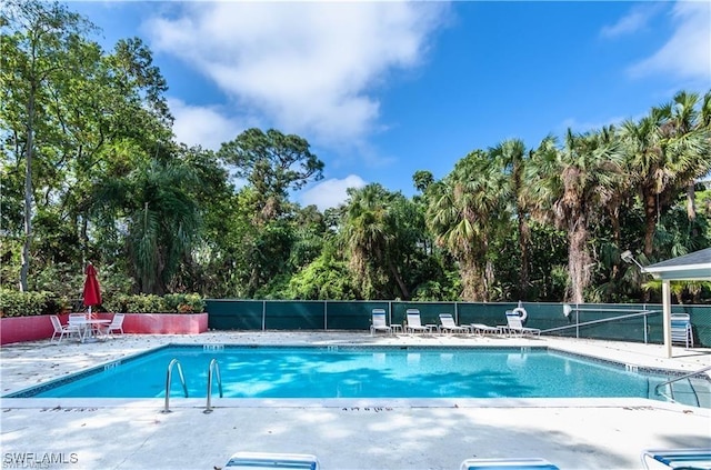 1431 Monarch Cir Unit B8, Naples, FL 34116 - community pool featuring fence, a patio area, and view of scattered trees