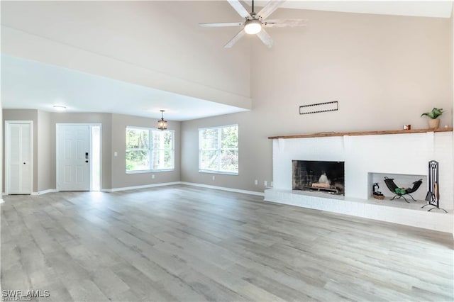 1431 Monarch Cir Unit B8, Naples, FL 34116 - unfurnished living room featuring baseboards, wood finished floors, a brick fireplace, a ceiling fan, and a towering ceiling