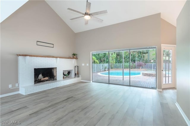 1431 Monarch Cir Unit B8, Naples, FL 34116 - unfurnished living room featuring high vaulted ceiling, baseboards, ceiling fan, wood finished floors, and a fireplace