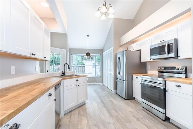 1431 Monarch Cir Unit B8, Naples, FL 34116 - kitchen with stainless steel appliances, wood counters, lofted ceiling, a sink, and white cabinets