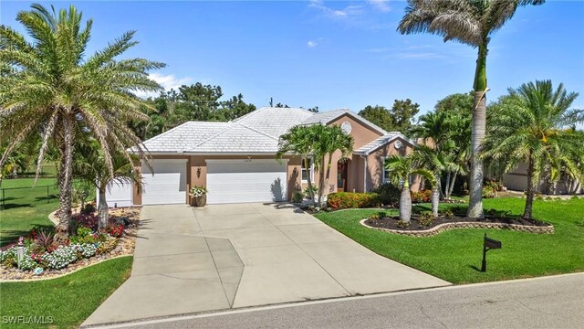 16232 Quesa Dr, Punta Gorda, FL 33955 - view of front of house with a front lawn, an attached garage, driveway, stucco siding, and a tile roof
