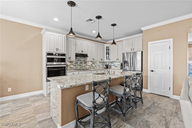16232 Quesa Dr, Punta Gorda, FL 33955 - kitchen featuring stainless steel appliances, a sink, under cabinet range hood, crown molding, and tasteful backsplash