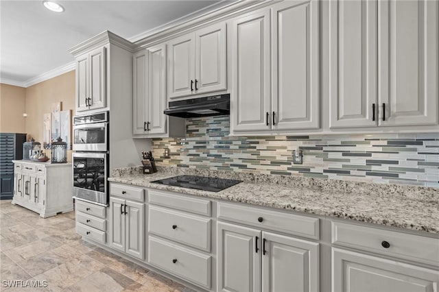 16232 Quesa Dr, Punta Gorda, FL 33955 - kitchen with black electric stovetop, under cabinet range hood, crown molding, tasteful backsplash, and stainless steel double oven
