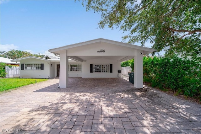 1300 Hilltop Dr, Naples, FL 34103 - view of front facade with fence, decorative driveway, stucco siding, and an attached carport