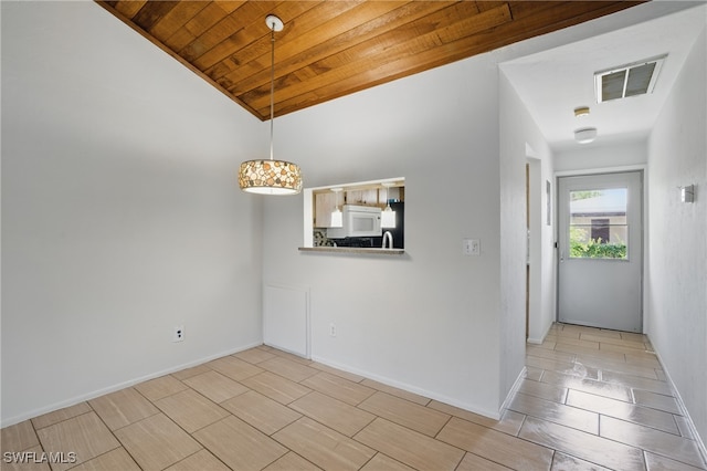 empty room featuring wood ceiling, lofted ceiling, and baseboards