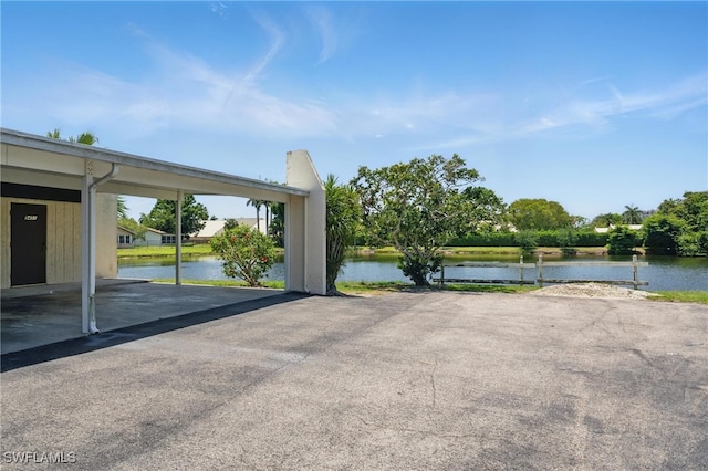 view of car parking featuring a water view