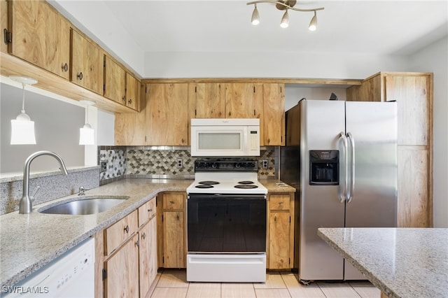 kitchen with white appliances, a sink, tasteful backsplash, and light stone counters
