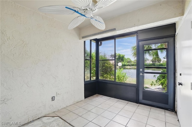 unfurnished sunroom with a water view and ceiling fan