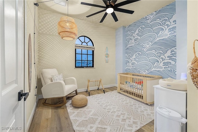4820 SW 17th Pl Unit 6, Cape Coral, FL 33914 - bedroom featuring wood finished floors, baseboards, a crib, and wallpapered walls