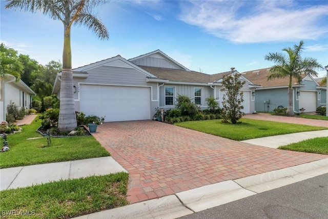1256 Enbrook Loop, Naples, FL 34114 - ranch-style house featuring an attached garage, decorative driveway, a front yard, and stucco siding
