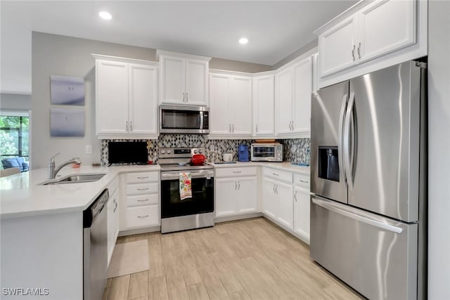1256 Enbrook Loop, Naples, FL 34114 - kitchen featuring appliances with stainless steel finishes, a sink, light countertops, white cabinetry, and tasteful backsplash