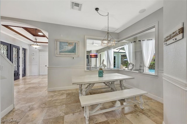 1817 Piccadilly Cir, Cape Coral, FL 33991 - dining room featuring arched walkways, a wainscoted wall, light stone finish floors, and a chandelier