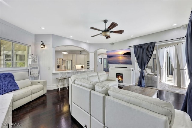 1817 Piccadilly Cir, Cape Coral, FL 33991 - living area featuring ceiling fan, dark wood-type flooring, arched walkways, recessed lighting, and a lit fireplace