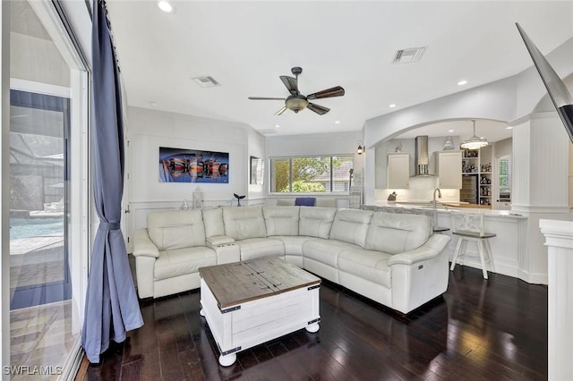 1817 Piccadilly Cir, Cape Coral, FL 33991 - living room featuring a ceiling fan, dark wood-style flooring, a decorative wall, arched walkways, and recessed lighting