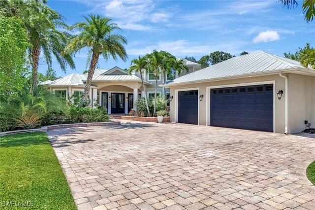 1817 Piccadilly Cir, Cape Coral, FL 33991 - single story home with decorative driveway, stucco siding, french doors, and a standing seam roof
