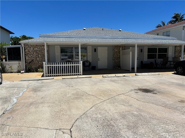 1185 Cherrystone Ct Unit A, Naples, FL 34102 - view of front of property with uncovered parking, stone siding, covered porch, and a shingled roof