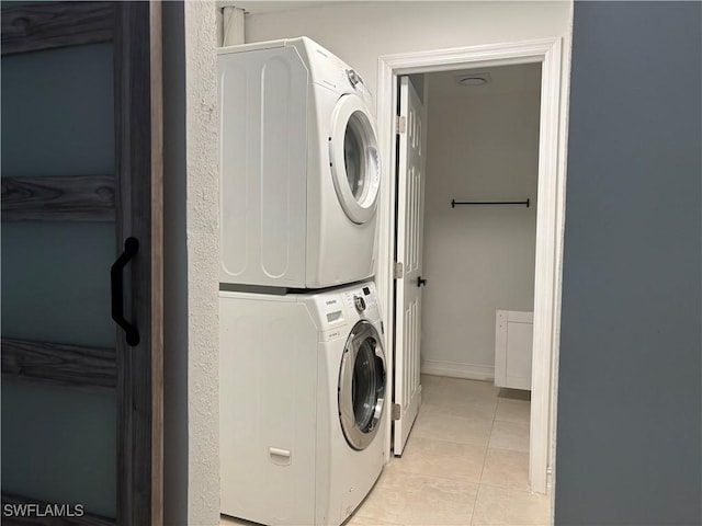 1185 Cherrystone Ct Unit A, Naples, FL 34102 - washroom with stacked washer / drying machine, light tile patterned flooring, and baseboards