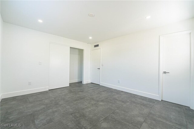 2564 Poinciana St, Naples, FL 34105 - unfurnished bedroom featuring baseboards, recessed lighting, a closet, and concrete flooring