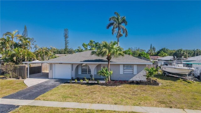 2564 Poinciana St, Naples, FL 34105 - ranch-style house with stucco siding, an attached garage, driveway, and a carport