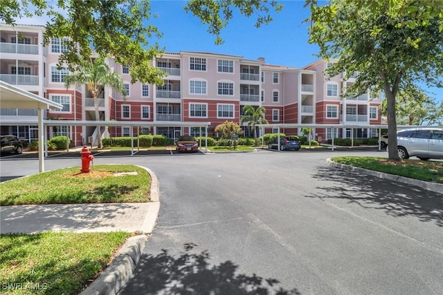 11711 Pasetto Ln Unit 407, Fort Myers, FL 33908 - view of apartment building / complex with covered and uncovered parking