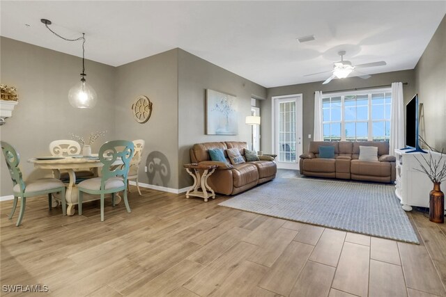11711 Pasetto Ln Unit 407, Fort Myers, FL 33908 - living room featuring light wood finished floors, baseboards, and ceiling fan