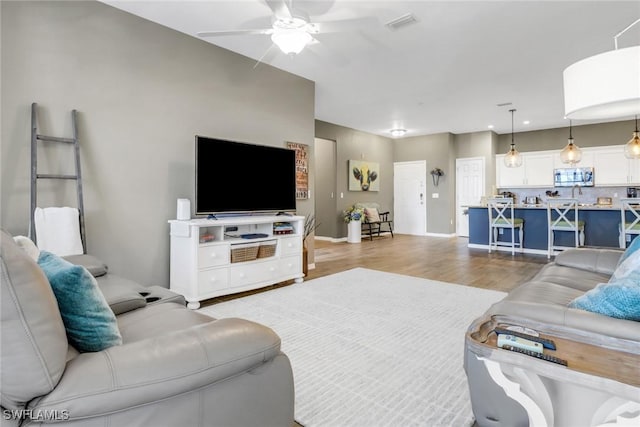 11711 Pasetto Ln Unit 407, Fort Myers, FL 33908 - living area featuring a ceiling fan, light wood-type flooring, and baseboards