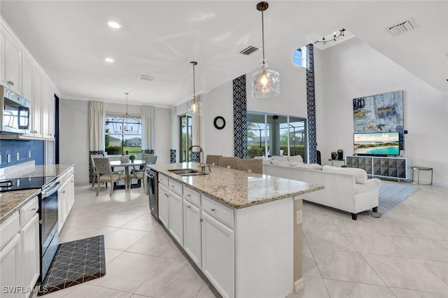 2369 Tangerine Ln, Naples, FL 34120 - kitchen with stainless steel appliances, a sink, light tile patterned flooring, light stone counters, and recessed lighting
