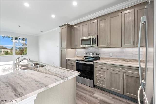 16077 Coruna Ct, Punta Gorda, FL 33955 - kitchen featuring appliances with stainless steel finishes, a sink, ornamental molding, tasteful backsplash, and light wood finished floors
