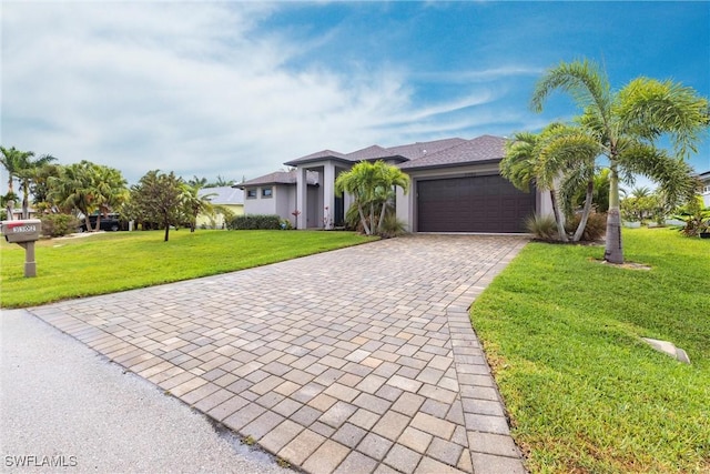 view of front of home with a front lawn, decorative driveway, a garage, and stucco siding