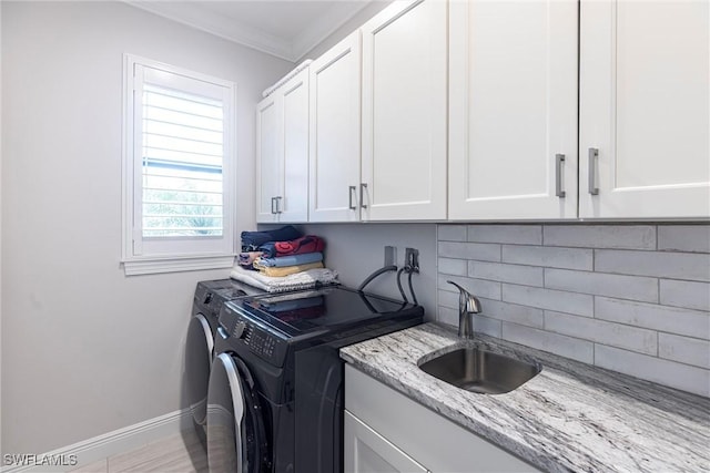 laundry area with cabinet space, washer and dryer, baseboards, and crown molding