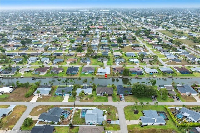 aerial view of property and surrounding area with nearby suburban area and a large body of water