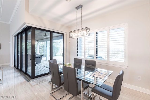 dining room with baseboards, ceiling fan, crown molding, and wood finished floors