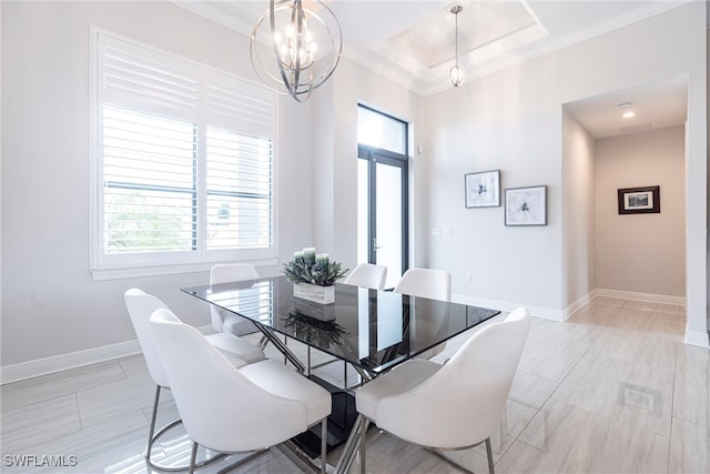 dining room featuring a chandelier, healthy amount of natural light, crown molding, baseboards, and a tray ceiling