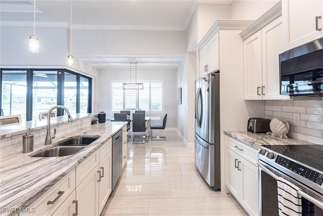 kitchen featuring appliances with stainless steel finishes, a sink, tasteful backsplash, white cabinetry, and light stone countertops