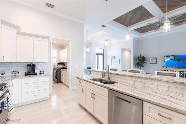kitchen featuring stainless steel appliances, a sink, crown molding, coffered ceiling, and independent washer and dryer