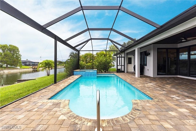 view of swimming pool with a water view, a patio, a pool with connected hot tub, and a yard