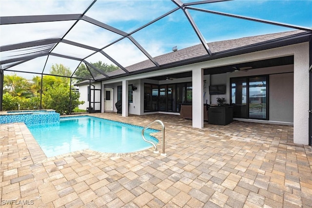 view of swimming pool featuring a ceiling fan, a patio area, a pool with connected hot tub, and a lanai