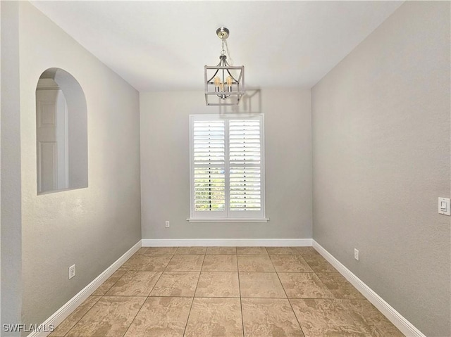 3290 37th Ave NE, Naples, FL 34120 - spare room with a chandelier, baseboards, light tile patterned floors, and arched walkways