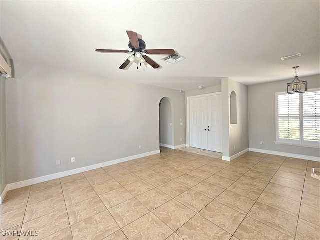 3290 37th Ave NE, Naples, FL 34120 - unfurnished room with arched walkways, a ceiling fan, light tile patterned floors, and baseboards