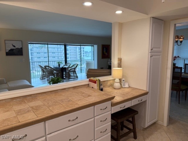 2880 Gulf Shore Blvd N Unit 404, Naples, FL 34103 - kitchen featuring white cabinetry, recessed lighting, light tile patterned floors, tile countertops, and built in desk